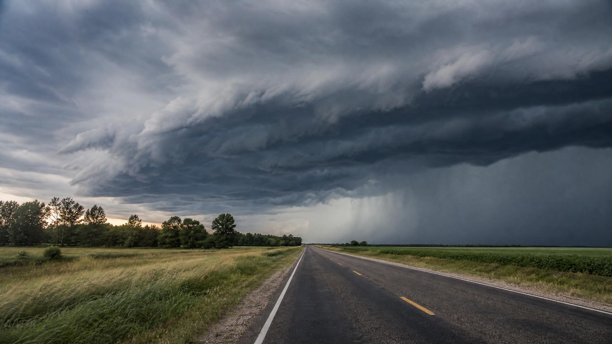 Dark severe thunderstorm clouds over a rural highway in the American South
